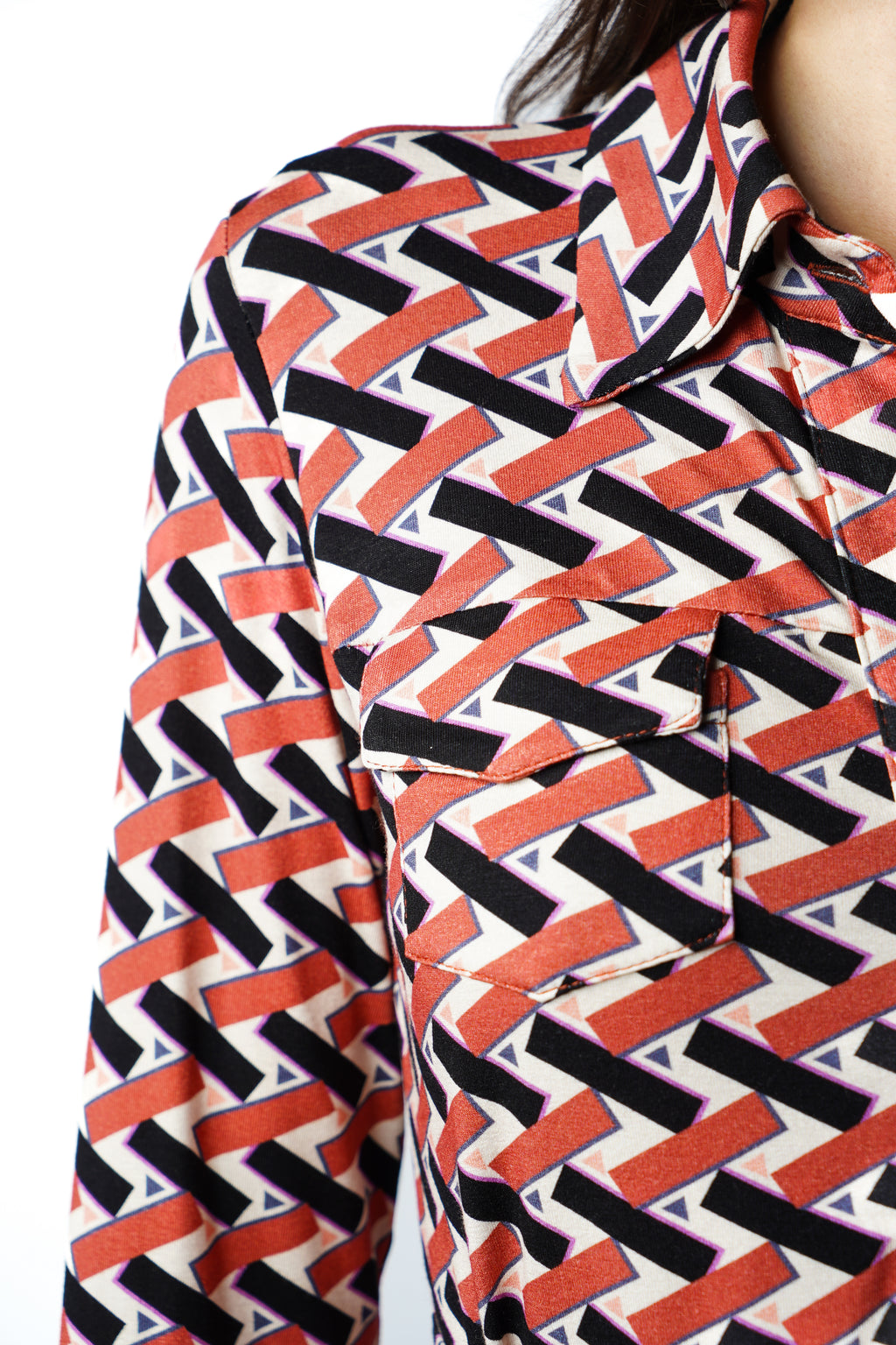 Robe à imprimé géométrique rouge noir et blanc. Coupe mi-longue à l’élégance naturelle. Col chemisier, boutonnage intégral et poche poitrine boutonnée. Bas légèrement évasé et ceinture amovible à nouer pour structurer la silhouette. Fabriquée en France.