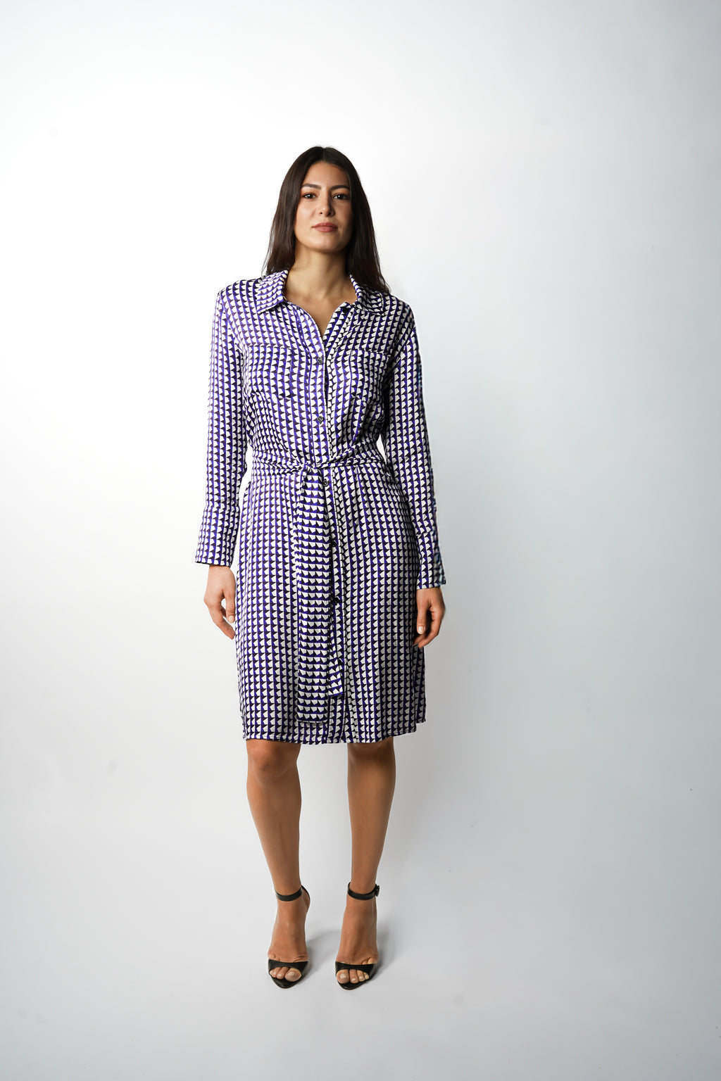 Robe à motif bleu mi-longue à l’élégance décontractée. Col chemisier, boutonnage intégral et poche poitrine. Manches boutonnées et ceinture assortie à nouer pour une allure féminine et moderne. Fabriquée en france