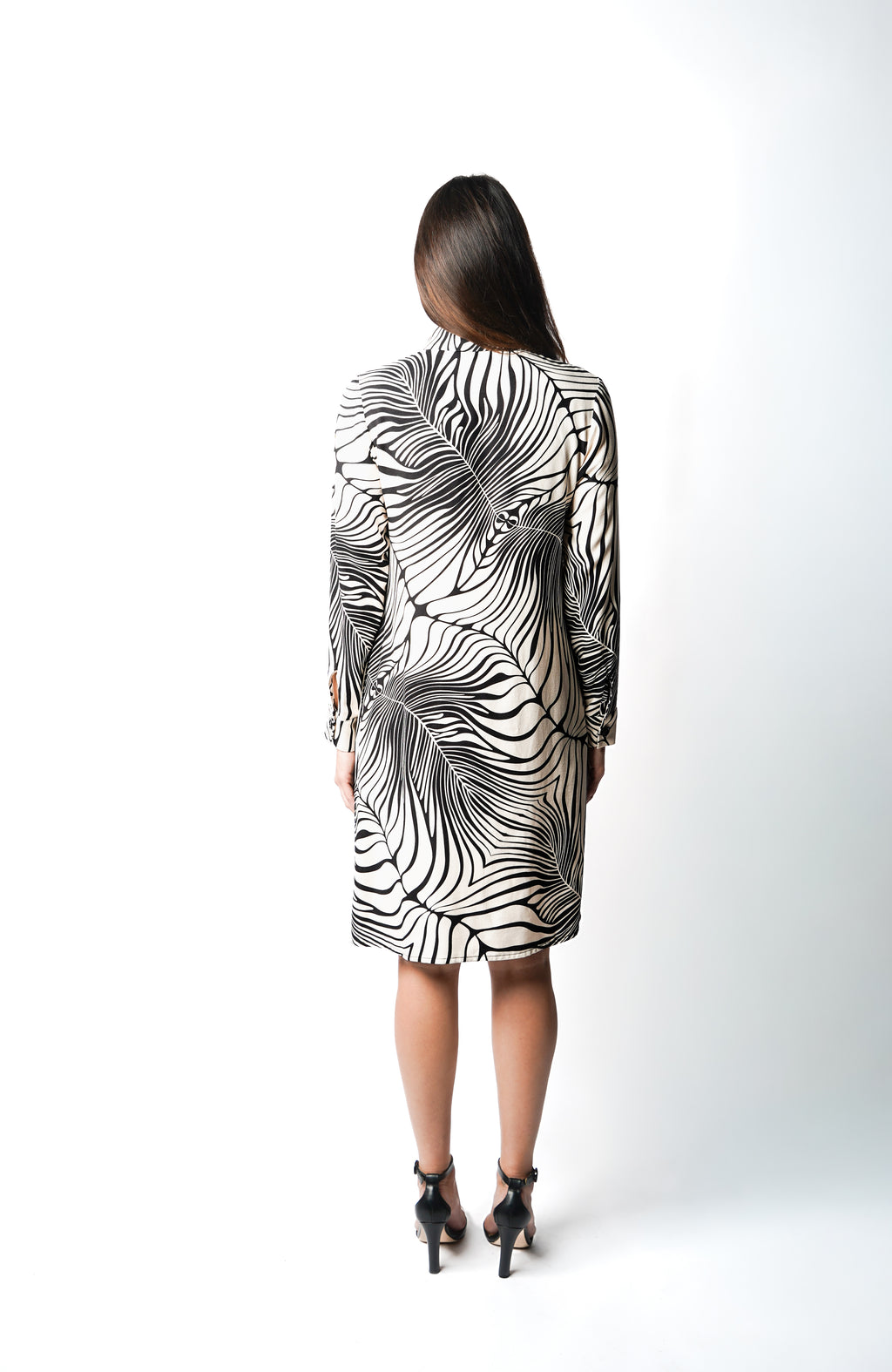 Robe polo à motif rayé zèbre, hauteur genoux. Col chemisier et patte de boutonnage pour un esprit chic et contemporain. Manches longues et poches discrètes dans les coutures. Fabriquée en France.