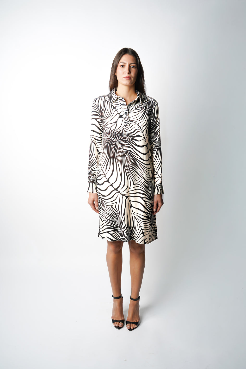 Robe polo à motif rayé zèbre, hauteur genoux. Col chemisier et patte de boutonnage pour un esprit chic et contemporain. Manches longues et poches discrètes dans les coutures. Fabriquée en France.